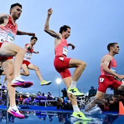 Kristian Imroth (izq.) de Inglaterra y Jean-Simon Desgagnes (centro) de Canadá compiten en la final de los 3000 metros con obstáculos masculinos durante la prueba de atletismo en el estadio Scotstoun de Glasgow, en el cuarto día de los Juegos de la Commonwealth en Glasgow, Escocia. | Foto:Ben Stansall / AFP