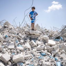 Un niño palestino se encuentra sobre un montón de escombros de un edificio que albergaba tiendas y apartamentos, demolido por las fuerzas israelíes alegando falta de permiso de construcción, en Arraba, al sur de la ciudad palestina de Jenin, en el norte de Cisjordania, territorio ocupado por Israel. | Foto:JOHN WESSELS / AFP