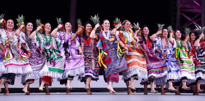 Imagen de artistas bailando en el Auditorio Guelaguetza, en la ciudad de Oaxaca, México. La Guelaguetza es una muestra anual de las culturas indígenas de México, caracterizada por música, danza y comida tradicional.