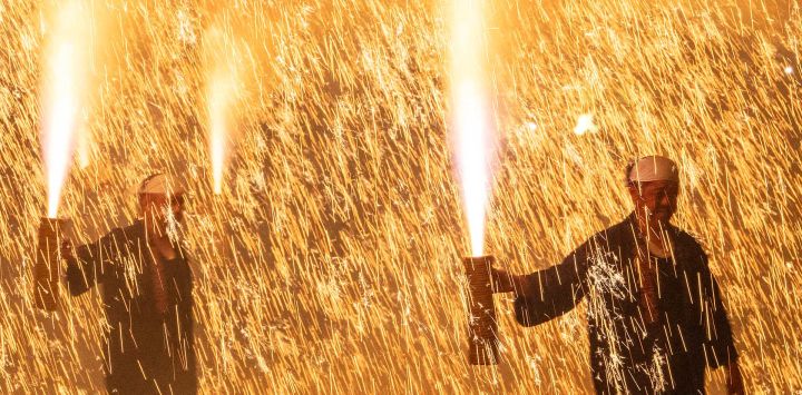 Los tezutsu-shu, artistas tradicionales de fuegos artificiales sostenidos con los brazos, sostienen un tezutsu hanabi, un tubo de bambú artesanal relleno de pólvora que estalla en una imponente columna de chispas y llamas, durante el Festival de Fuegos Artificiales de Brazo de Tatebayashi en Tatebayashi, prefectura de Gunma. Originarios de la actual prefectura de Aichi hace más de 450 años, los tezutsu hanabi se ofrecían tradicionalmente en los santuarios sintoístas en oraciones por buenas cosechas, salud y prosperidad, y siguen siendo una de las tradiciones pirotécnicas más distintivas de Japón.
