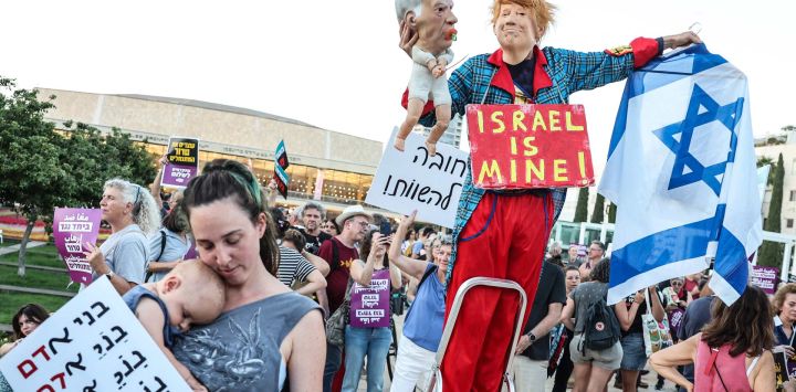 Un manifestante disfrazado del presidente estadounidense Donald Trump, sosteniendo una marioneta que representa al primer ministro israelí Benjamin Netanyahu, posa mientras una mujer sostiene a un bebé en brazos durante una manifestación en Tel Aviv, en protesta contra los recientes ataques violentos de colonos israelíes en Cisjordania, territorio ocupado por Israel. La violencia en Cisjordania se ha intensificado desde el inicio de la guerra de Gaza con el ataque de Hamás contra Israel el 7 de octubre de 2023, y grupos de derechos humanos y la ONU informan de ataques casi diarios por parte de colonos israelíes.