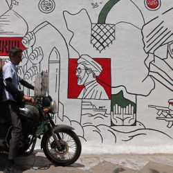 En la foto se ve a un motocicleta frente a un mural en una calle de Teherán. La Guardia Revolucionaria iraní declaró que atacó objetivos militares estadounidenses, incluidos sistemas de defensa aérea en Bahréin y Kuwait, según informó la agencia estatal de noticias IRNA. | Foto:ATTA KENARE / AFP
