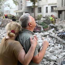 Residentes locales reaccionan frente a un edificio residencial parcialmente destruido por ataques con misiles rusos en la ciudad de Lviv, al oeste de Ucrania, en medio de la invasión rusa a Ucrania. | Foto:YURIY DYACHYSHYN / AFP