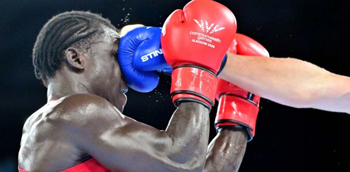 El ugandés Aziz Abdul (rojo) se enfrenta al inglés Damar Thomas (azul) en el combate de cuartos de final de la categoría masculina de más de 90 kg durante el evento de boxeo celebrado en el Centro de Exposiciones de Glasgow, en el sexto día de los Juegos de la Commonwealth en Glasgow, Escocia.