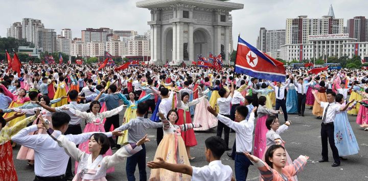Jóvenes y estudiantes bailan en la plaza del Arco del Triunfo para conmemorar el 73.º aniversario del fin de la Guerra de Corea en Pyongyang.
