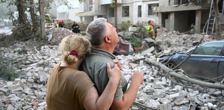 Residentes locales reaccionan frente a un edificio residencial parcialmente destruido por ataques con misiles rusos en la ciudad de Lviv, al oeste de Ucrania, en medio de la invasión rusa a Ucrania.