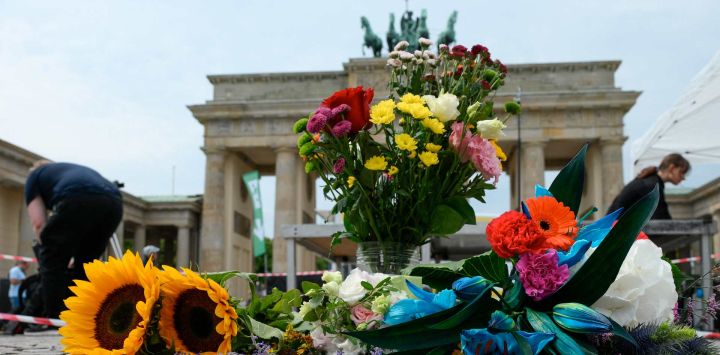 Varias personas colocaron ramos de flores frente a la emblemática Puerta de Brandeburgo, antes de un acto de duelo comunitario, un día después del atropello perpetrado en las inmediaciones del desfile del Día de Christopher Street (CSD) de Berlín, que dejó un muerto y 16 heridos en el parque Tiergarten.