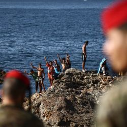 Miembros de las fuerzas de infantería regulares del Ejército español observan a un grupo de migrantes cerca del puesto fronterizo del enclave español de Ceuta. Al menos 72 personas murieron durante la llegada masiva de migrantes a Ceuta la semana pasada, cuando decenas de miles de personas, en su mayoría nadando, rodearon el puesto fronterizo desde Marruecos, según informaron hoy las autoridades locales. La mayoría de las aproximadamente 60.000 personas que se precipitaron al territorio español del norte de África han regresado a Marruecos tras el mayor cruce migratorio masivo en la historia del país. | Foto:HENRY NICHOLLS / AFP