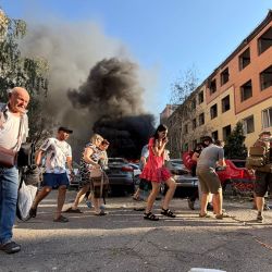 Varias personas se alejan frente a una densa columna de humo que se eleva en el lugar de un ataque aéreo ruso en Zaporiyia, en medio de la invasión rusa de Ucrania. | Foto:Darya Nazarova / AFP