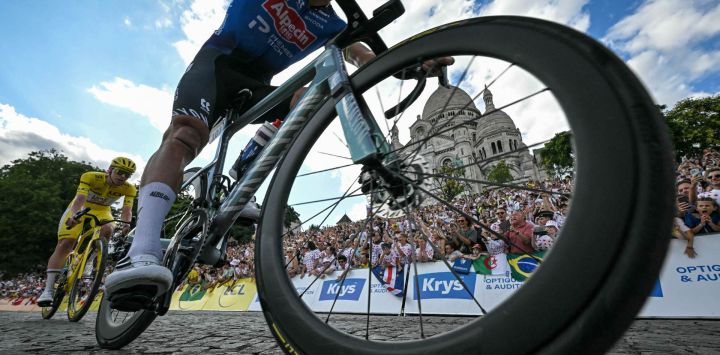 El ciclista esloveno Tadej Pogacar, del equipo UAE Team Emirates - XRG, con el maillot amarillo de líder de la clasificación general, persigue al ciclista neerlandés Mathieu van der Poel, del equipo Alpecin - Premier Tech, mientras pasan junto a la basílica del Sacré-Cœur durante la 21ª etapa de la 113ª edición del Tour de Francia, una carrera ciclista de 88,7 km con salida y llegada en París.
