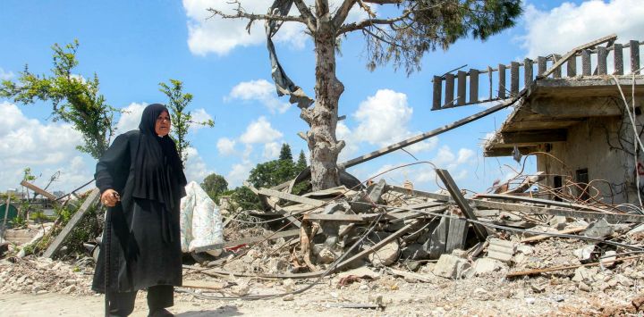 Una mujer pasa junto a un edificio destruido en la aldea de Zawtar al-Gharbiyeh, en el sur del Líbano. El ejército libanés había comenzado a desplegarse en Zawtar al-Gharbiyeh como parte de un acuerdo marco patrocinado por Estados Unidos y firmado por el Líbano e Israel el mes anterior. Según el acuerdo, el ejército debe desarmar a Hezbolá y el ejército israelí debe retirarse de las "zonas piloto" donde posteriormente se desplegarán las tropas libanesas.