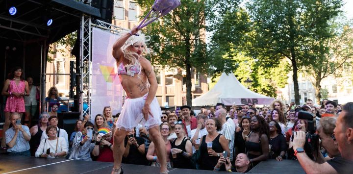 Una participante en un concurso de drag lanza un bolso durante la prueba de lanzamiento de bolsos al comienzo de las Olimpiadas Drag en Ámsterdam.