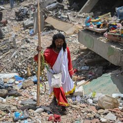 El pastor evangélico colombiano Telmo Velazco camina entre los escombros de los edificios dañados por los terremotos del 24 de junio en Caraballeda, Venezuela. | Foto:Federico Parra / AFP