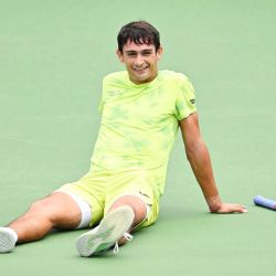 Mariano Navone, de Argentina, permanece sentado en la cancha mientras el juego se suspende debido a la lluvia contra Mateo Berrettini, de Italia, durante su partido de primera ronda individual en el segundo día del ATP 1000 National Bank Open presentado por Rogers en el Stade IGA en Montreal, Quebec, Canadá. | Foto:Minas Panagiotakis / Getty Images / AFP