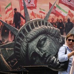 Una mujer iraní pasa junto a una valla publicitaria antiestadounidense en la plaza Enghelab, en el centro de Teherán. Irán negó que se estuvieran llevando a cabo negociaciones con Estados Unidos después de que el presidente estadounidense anunciara el inicio de nuevas conversaciones en un intento por poner fin a la guerra, que ya lleva seis meses. Washington y Teherán están en guerra desde el 28 de febrero, cuando Estados Unidos e Israel lanzaron ataques sorpresa contra Irán, aunque meses de diplomacia intermitente han propiciado periodos de relativa calma. | Foto:ATTA KENARE / AFP
