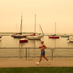 Una persona corre por la orilla del río en Toronto mientras los incendios forestales en el norte de Ontario provocan una mala calidad del aire en la ciudad, en Toronto, Ontario, Canadá. | Foto:COLE BURSTON / AFP