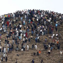 Varias personas se congregan en una colina cercana al lugar de los enfrentamientos cerca de Fnideq, en la frontera entre Marruecos y España. Miles de migrantes cruzaron durante la noche desde Marruecos al enclave español de Ceuta, en el norte de África, según informó una fuente policial, quien añadió que era imposible calcular el número total de personas. | Foto:Abdel Majid Bziouat / AFP