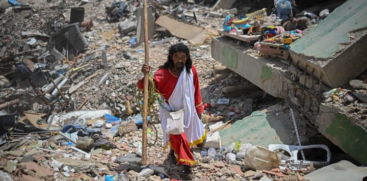 El pastor evangélico colombiano Telmo Velazco camina entre los escombros de los edificios dañados por los terremotos del 24 de junio en Caraballeda, Venezuela.