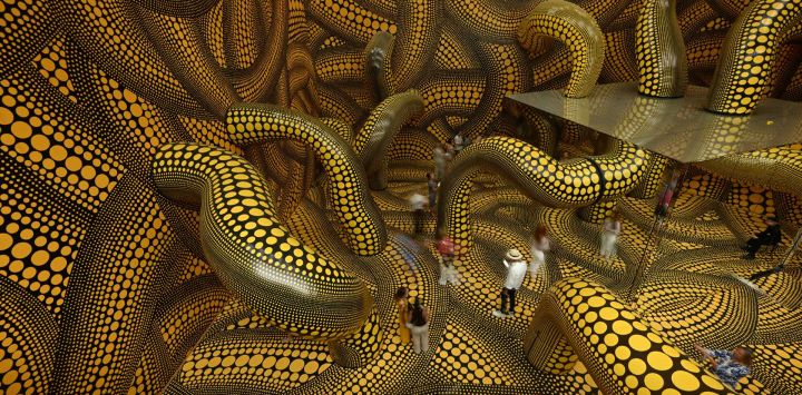 Los visitantes recorren la instalación "Sala de Espejos Infinitos: La esperanza de que los lunares enterrados en el infinito cubran eternamente el universo" durante el último día de la exposición "Yayoi Kusama" de la artista japonesa Yayoi Kusama en el Museo Ludwig de Colonia, Alemania Occidental.
