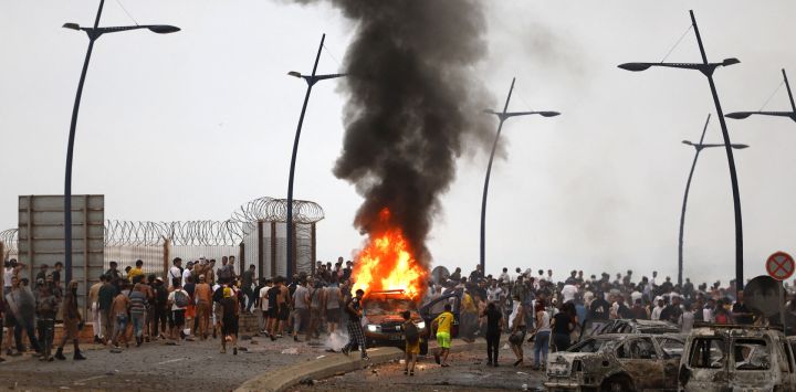 Un vehículo arde en el lugar de los enfrentamientos cerca de Fnideq, en la frontera entre Marruecos y España. Miles de migrantes cruzaron durante la noche desde Marruecos al enclave español de Ceuta.