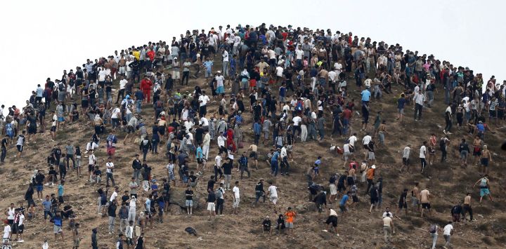 Varias personas se congregan en una colina cercana al lugar de los enfrentamientos cerca de Fnideq, en la frontera entre Marruecos y España. Miles de migrantes cruzaron durante la noche desde Marruecos al enclave español de Ceuta, en el norte de África, según informó una fuente policial, quien añadió que era imposible calcular el número total de personas.