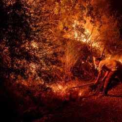 Un voluntario utiliza una pala para combatir un incendio forestal en el distrito de Seydikemer, en Mugla. Los bomberos turcos lucharon contra incendios forestales cerca de las playas turísticas del sur del país, que obligaron a la evacuación de cientos de personas, según informaron las autoridades. | Foto:Murat Kocabas / AFP