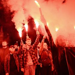 Varias personas portan bengalas durante un acto conmemorativo del cuarto aniversario de la muerte de decenas de soldados ucranianos en el bombardeo de 2022, de la prisión rusa de Olenivka, en la región oriental de Donetsk, frente a la Catedral de San Miguel de las Cúpulas Doradas en Kiev, en el contexto de la invasión rusa de Ucrania. | Foto:GENYA SAVILOV / AFP