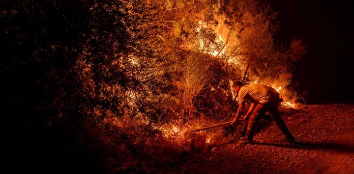 Un voluntario utiliza una pala para combatir un incendio forestal en el distrito de Seydikemer, en Mugla. Los bomberos turcos lucharon contra incendios forestales cerca de las playas turísticas del sur del país, que obligaron a la evacuación de cientos de personas, según informaron las autoridades.