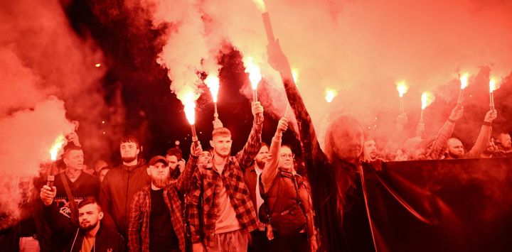 Varias personas portan bengalas durante un acto conmemorativo del cuarto aniversario de la muerte de decenas de soldados ucranianos en el bombardeo de 2022, de la prisión rusa de Olenivka, en la región oriental de Donetsk, frente a la Catedral de San Miguel de las Cúpulas Doradas en Kiev, en el contexto de la invasión rusa de Ucrania.
