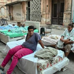 Residentes sentados y acostados en camas colocadas en una calle del barrio de Centro Habana tras el derrumbe parcial de su edificio en La Habana. Los cubanos se enorgullecen de afrontar las dificultades con resiliencia e ingenio, pero esa fortaleza está teniendo un alto costo psicológico en medio de la última crisis prolongada de la isla. | Foto:YAMIL LAGE / AFP