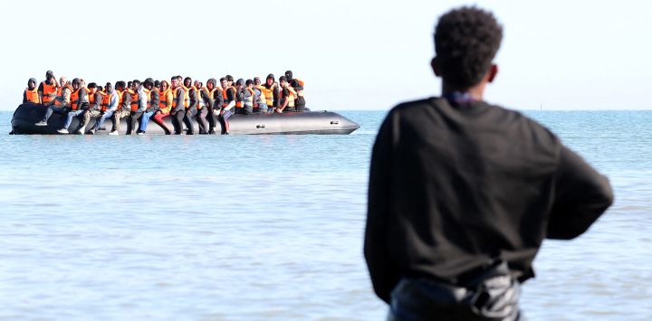 Migrantes a bordo de una embarcación de traficantes intentan cruzar el Canal de la Mancha frente a la playa de Gravelines, en el norte de Francia.
