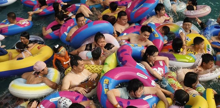 En Shenyang, provincia de Liaoning, noreste de China, la gente se agolpa en una piscina de olas en un parque acuático para refrescarse del calor.