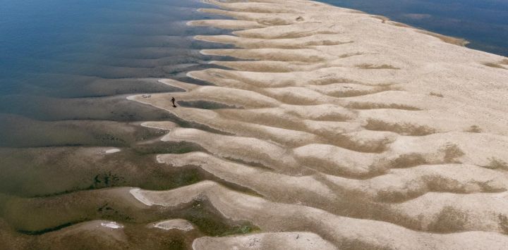 Esta fotografía aérea muestra a un hombre caminando sobre los bancos de arena que quedaron al descubierto tras el descenso del nivel del agua del río Danubio en Batina, al noreste de Croacia.