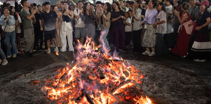 Imagen de personas del grupo étnico yi festejando una noche de carnaval de la antorcha con visitantes, en el distrito de Yuexi de la provincia de Sichuan, en el suroeste de China.