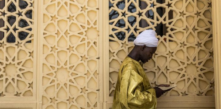 Un seguidor de la Hermandad Mouride reza junto al mausoleo de Serigne Fallou Mbacke, el segundo califa del Mouridismo, dentro de la Gran Mezquita de Touba durante el Gran Magal, una peregrinación religiosa anual que conmemora la partida al exilio del fundador de la hermandad, Cheikh Ahmadou Bamba, en Touba, Senegal.