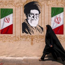Una mujer pasa junto a un mural que representa al difunto líder supremo de Irán, Ali Khamenei, en la plaza Valiasr, en el centro de Teherán. Las esperanzas de un inminente acuerdo entre Estados Unidos e Irán para poner fin al bloqueo del estrecho de Ormuz aumentaron el optimismo de que el petróleo y el gas, junto con otros productos clave, volverían a fluir libremente después de más de cinco meses de guerra. Pero los precios del petróleo subieron antes del fin de semana ante la ausencia de confirmación de un acuerdo, en medio de informes de que Irán planeaba bloquear el paso de barcos estadounidenses e israelíes por la vía marítima. | Foto:ATTA KENARE / AFP