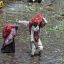 Fotogaleria Personas que transportan sacos de verduras caminan con dificultad por un mercado inundado tras las fuertes lluvias en Lahore, Pakistán