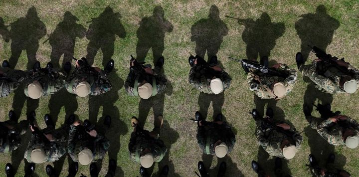 En esta vista aérea, miembros del Servicio Nacional de Fronteras de Panamá (SENAFRONT) montan guardia durante una formación previa al inicio de la "Operación Escudo de Acero Fase 5" en la base militar Meteti, en la provincia de Darién, Panamá, mientras un helicóptero sobrevuela la zona. Panamá reforzó su frontera con Colombia, tras los ataques ocurridos el primer día de la administración del presidente colombiano Abelardo de la Espriella, según anunció el gobierno panameño. El gobierno había descartado recientemente la posibilidad de incursiones en su territorio por parte de grupos irregulares colombianos.