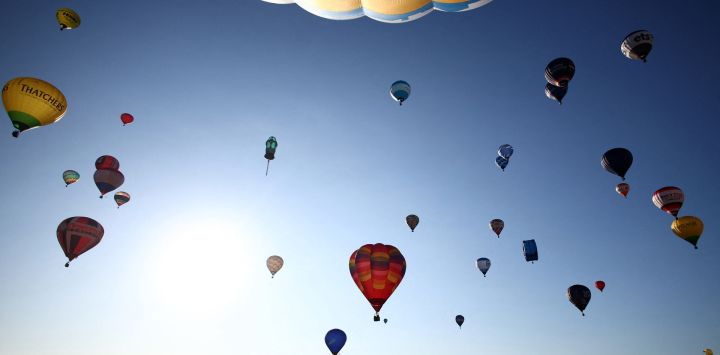 Globos aerostáticos se elevan en un ascenso masivo al amanecer durante el festival internacional de globos de Bristol, en Bristol, al oeste de Inglaterra.