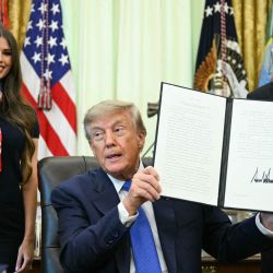 El presidente estadounidense Donald Trump firma una orden ejecutiva que exige mayor investigación y flexibilidad en materia de vacunas, junto al secretario de Salud y Servicios Humanos, Robert F. Kennedy Jr. (derecha), y Jayme Leagh Franklin (izquierda), fundadora de The Conservateur, en el Despacho Oval de la Casa Blanca en Washington, D.C.. | Foto:JIM WATSON / AFP