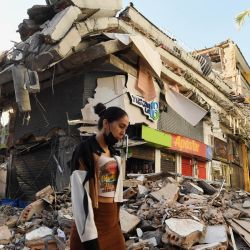 Una mujer camina entre los escombros de un edificio derrumbado tras el terremoto en Pereira, Colombia. Voluntarios y rescatistas colombianos retiraron los escombros con sus propias manos en busca de sobrevivientes luego del terremoto más fuerte que ha azotado el país en una década, que dejó al menos 169 muertos y destruyó decenas de edificios. | Foto:JAIME SALDARRIAGA / AFP