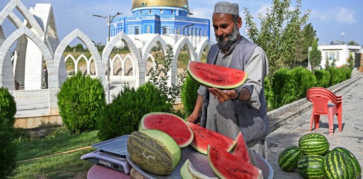 Un vendedor afgano corta sandías mientras espera clientes en la cima de la colina Wazir Akbar Khan en Kabul.