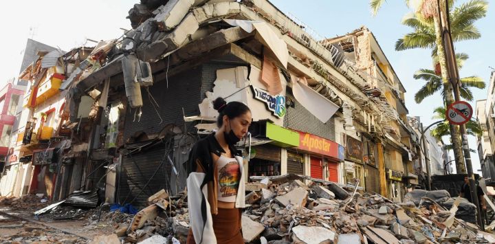 Una mujer camina entre los escombros de un edificio derrumbado tras el terremoto en Pereira, Colombia. Voluntarios y rescatistas colombianos retiraron los escombros con sus propias manos en busca de sobrevivientes luego del terremoto más fuerte que ha azotado el país en una década, que dejó al menos 169 muertos y destruyó decenas de edificios.