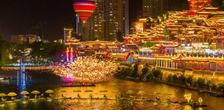 Vista aérea tomada con un dron de personas navegando en balsas de bambú en el río Gongshui, en el distrito de Xuan'en, en la provincia de Hubei, en el centro de China. Una serie de recorridos nocturnos se ha puesto en marcha a lo largo de los paseos marítimos en el distrito de Xuan'en para enriquecer los escenarios turísticos nocturnos locales y dinamizar la vitalidad cultural y turística de este pequeño poblado de montaña.