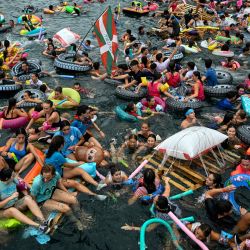 Los asistentes a la fiesta zarpan en balsas y flotadores improvisados desde el puerto hacia la playa de la bahía de La Concha durante el  evento festivo "Pirata Abordaia" en la ciudad vasca de San Sebastián, al norte de España. | Foto:ANDER GILLENEA / AFP