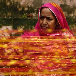 Una devota hindú ofrece oraciones mientras ata un hilo sagrado a un "Kalpavriksha", un árbol de los deseos divinos, con motivo de Hariyali Amavasya en un templo hindú en Ajmer, India. | Foto:Himanshu Sharma / AFP