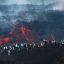 Fotogaleria visitantes junto a la lava que fluye del volcán Etna durante una erupción en Catania, en la isla mediterránea de Sicilia, Italia