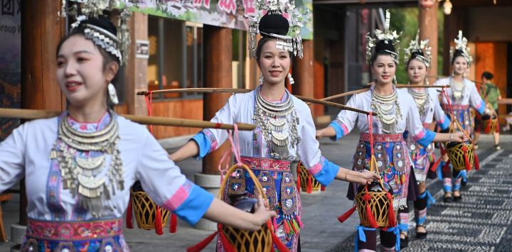 Imagen de actrices realizando una presentación durante un evento promocional, en el distrito autónomo dong de Sanjiang, en la región autónoma zhuang de Guangxi, en el sur de China. Un evento promocional para operadores turísticos se llevó a cabo en el que se exhibieron la cultura étnica y los recursos turísticos de la región mediante espectáculos, un tradicional "Banquete de las Cien Familias" y otras actividades.