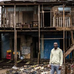 Francis Tugbiyele, de 42 años, representante de la comunidad, posa para una fotografía frente a la casa de su tío, que está siendo dañada por la erosión costera, en Ayetoro, estado de Ondo. Francis se aloja con su tío después de que su propia casa fuera destruida por la erosión costera y ahora se enfrenta a la reubicación por cuarta vez. "Estoy desesperado y asustado porque puede ocurrir en cualquier momento", dijo, refiriéndose a la posibilidad de que la casa de su tío sea destruida. La comunidad costera de Ayetoro, en el estado de Ondo, al suroeste de Nigeria, se ha convertido en uno de los ejemplos más visibles del país sobre la vulnerabilidad de las comunidades que viven a lo largo del océano Atlántico ante la erosión costera y el aumento del nivel del mar. | Foto:OLYMPIA DE MAISMONT / AFP