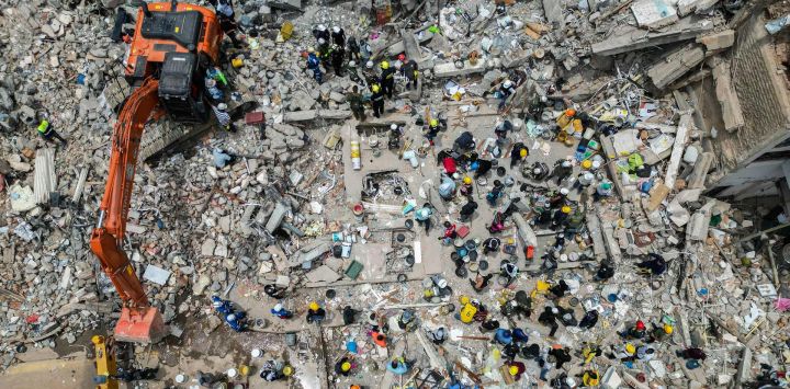 Esta vista aérea muestra la maquinaria pesada utilizada por los rescatistas en la búsqueda de sobrevivientes entre los escombros de un edificio derrumbado tras el terremoto de Pereira, Colombia. Rescatistas, soldados y voluntarios buscaron entre bloques de apartamentos y edificios de oficinas derrumbados en todo el oeste de Colombia, en una carrera contrarreloj para encontrar sobrevivientes después del terremoto más fuerte del país en un siglo, que dejó al menos 239 muertos y muchos más sin hogar.